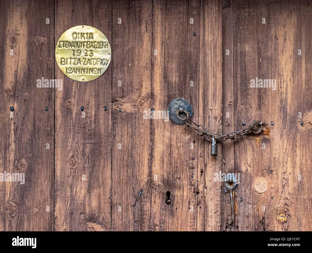 Antica porta nel villaggio montano di Vitsa Zagoria Grecia settentrionale con placca commemorativa in ottone (Stephan Vasdiki 1923 Vitsa Zagoria Ioannina) Foto Stock