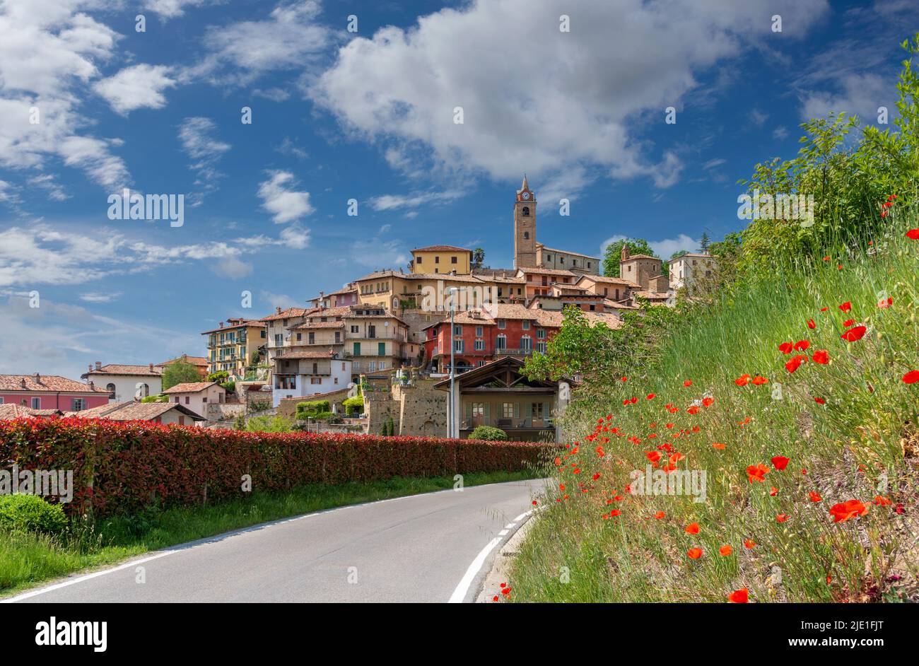 Monforte d'Alba, langhe, Italia: Vista del borgo medievale sulla collina con l'antico campanile e caratteristici edifici colorati su cielo blu e. Foto Stock