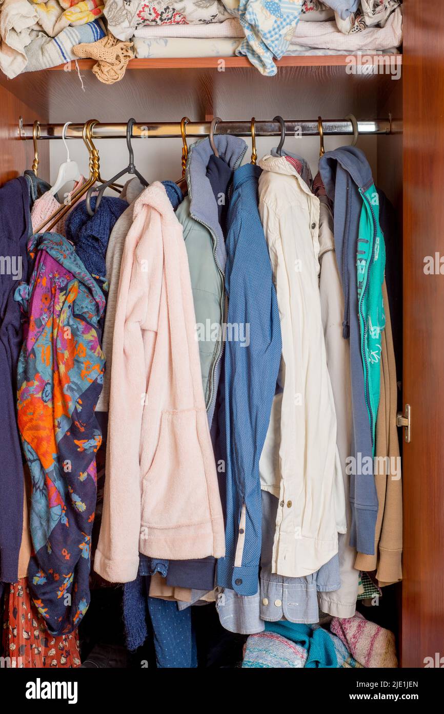 armadio aperto con vestiti su appendiabiti e disordine in cassetti aperti  Foto stock - Alamy