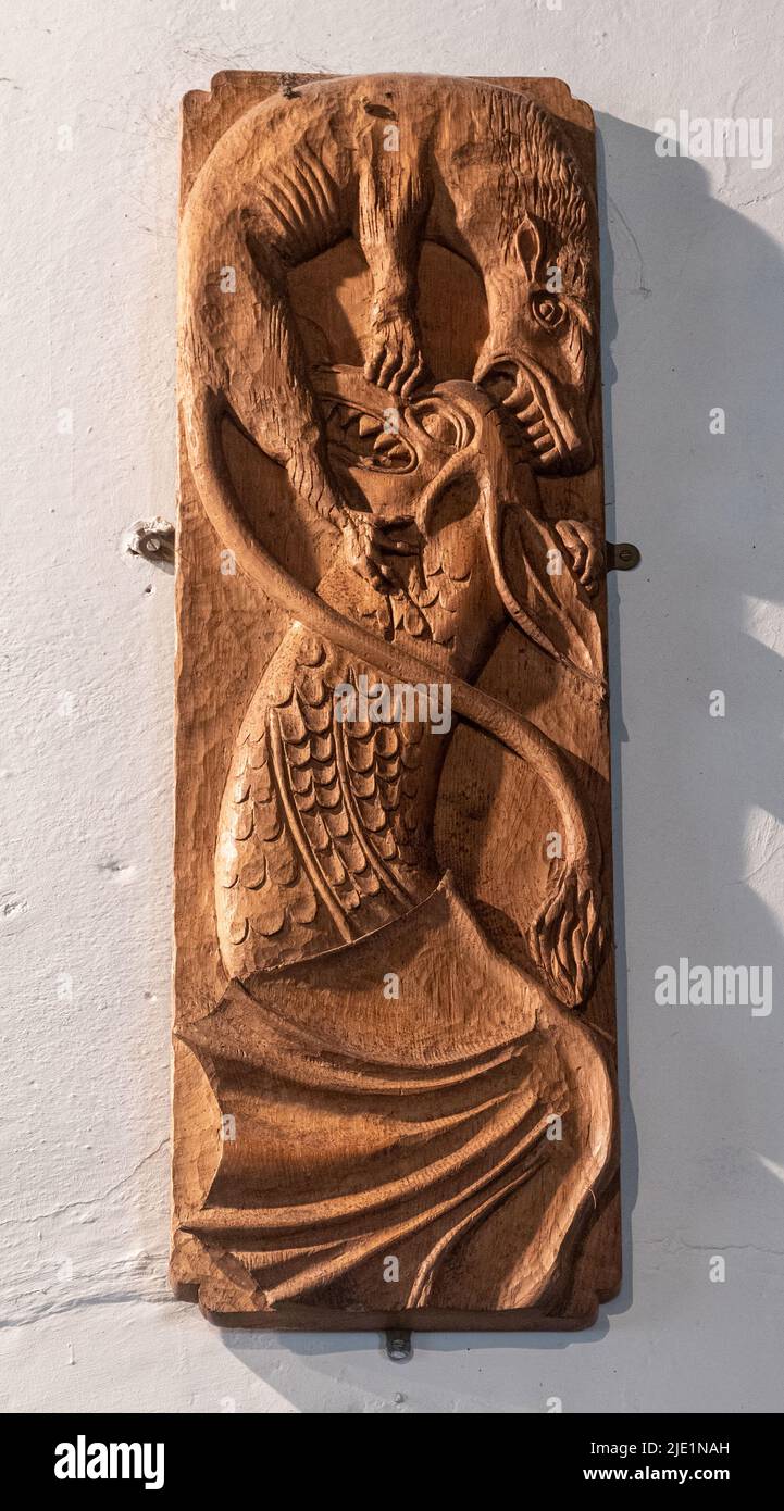 Interno della Chiesa di San Pietro e Paolo, West Clandon, Surrey, Inghilterra, Regno Unito. Scultura in legno raffigurante il drago di Clandon e la lotta del cane Foto Stock
