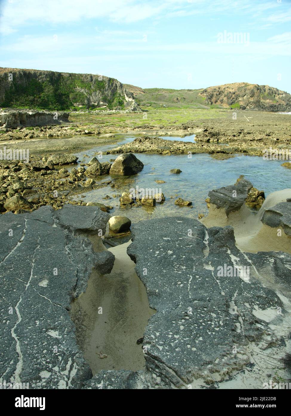 Clima tropicale crudo e mare ruvido. Cielo blu e spettacolari nuvole. Meraviglia geologica naturale formazione calcarea. La formazione rocciosa di Kapurpurawan. Foto Stock