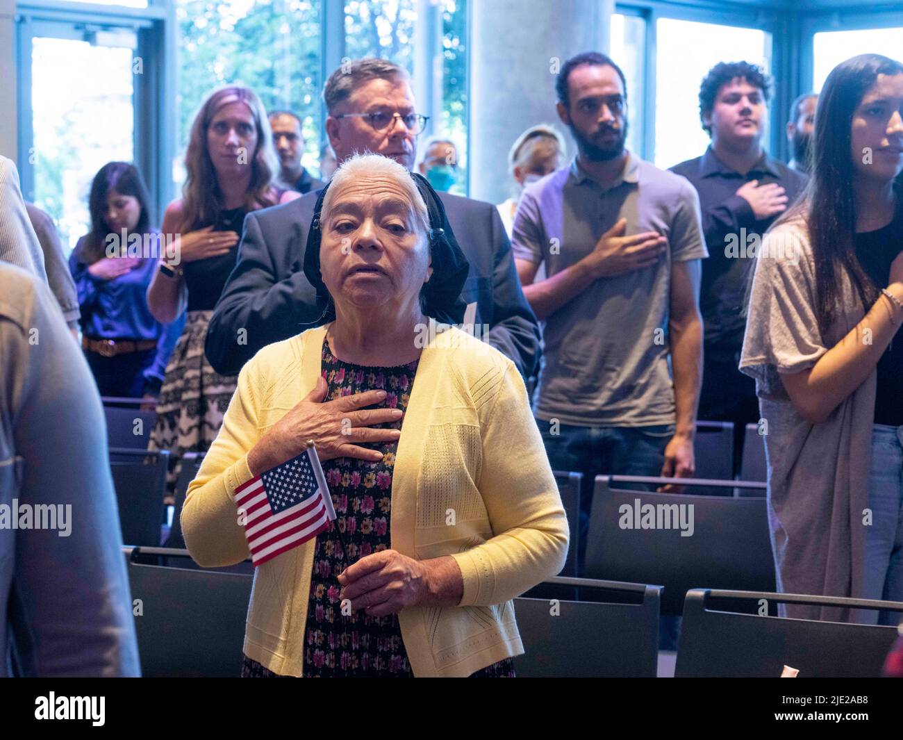 Austin Texas USA, 24 giugno 2022: I nuovi cittadini recitano l'impegno di Allegiance negli Stati Uniti mentre 95 nuovi cittadini degli Stati Uniti provenienti da 40 paesi stranieri prendono il giuramento di cittadinanza guidato da un giudice federale presso la Biblioteca Centrale di Austin. La cerimonia è uno dei numerosi eventi di cittadinanza previsti questa estate nel Texas centrale. Credit: Bob Daemmrich/Alamy Live News Foto Stock