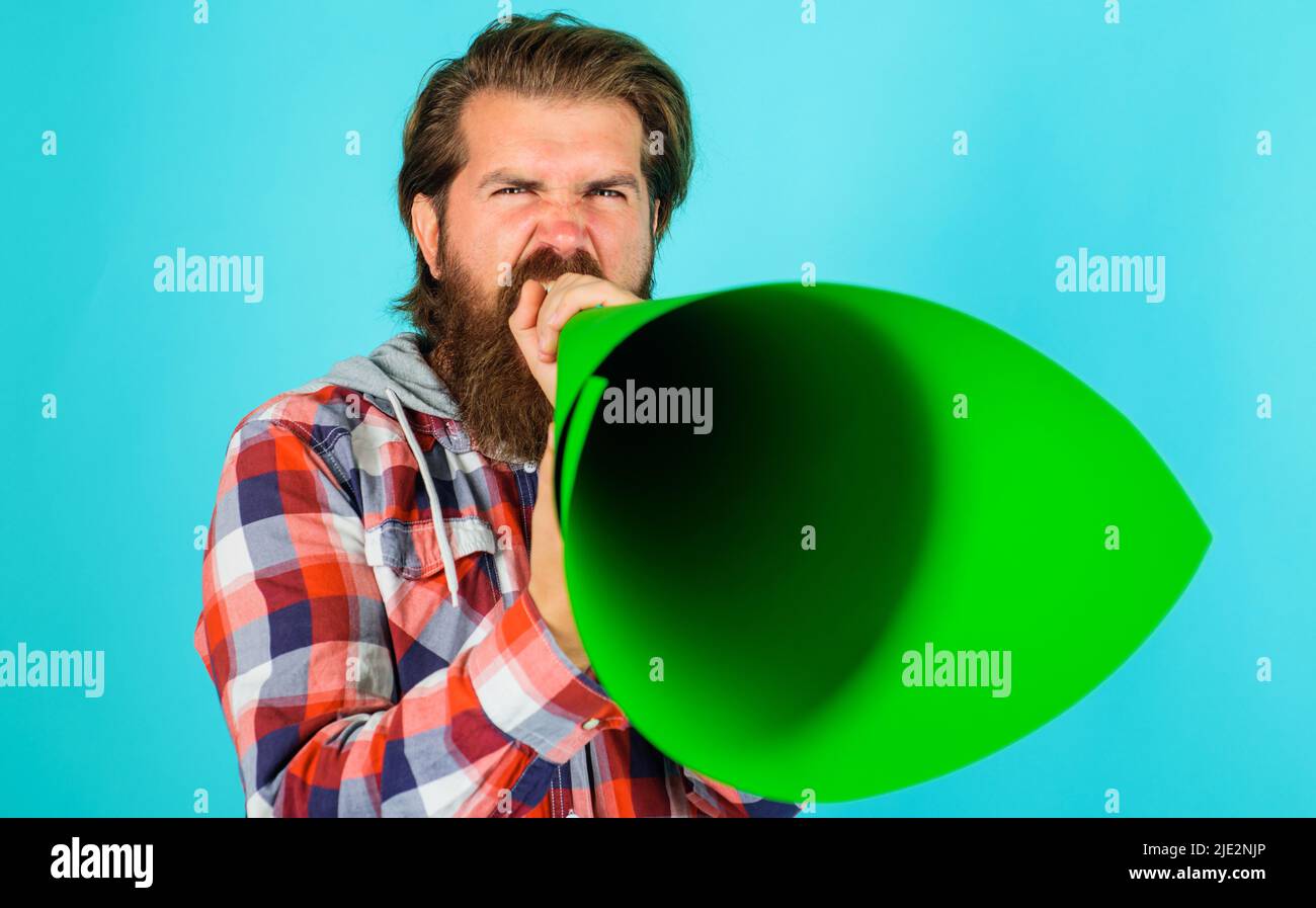 Uomo bearded che grida in altoparlante o megafono. Libertà di parola. Annuncio o diffusione di notizie. Foto Stock