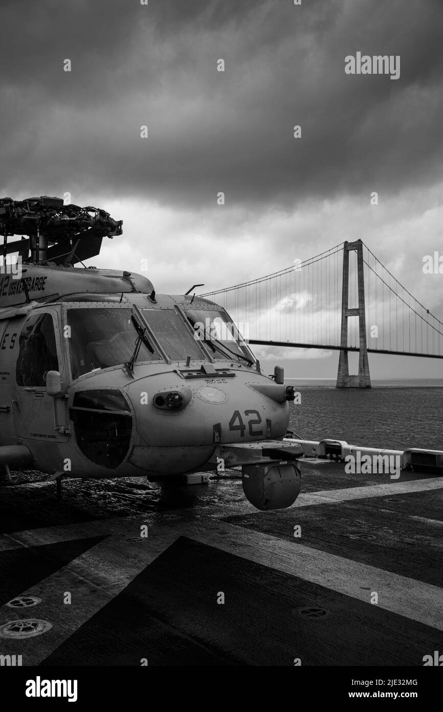 La nave d'assalto anfibio di classe Wasp USS Kearsarge (LHD 3) passa sotto il ponte Øresund mentre transita nello stretto danese il 20 giugno 2022. Il gruppo Kearsarge Amphibious Ready e l'unità Marine Expeditionary 22nd, sotto il comando e il controllo della Task Force 61/2, è in fase di dispiegamento programmato nell'area delle operazioni U.S. Naval Forces Europe, impiegata dalla U.S. Sesta flotta per difendere gli interessi degli Stati Uniti, degli alleati e dei partner. (STATI UNITI Illustrazione di foto Navy di Mass Communication Specialist 3rd Class Gwyneth Vandevender)(questa immagine è stata creata a colori e cambiata in bianco e nero) Foto Stock