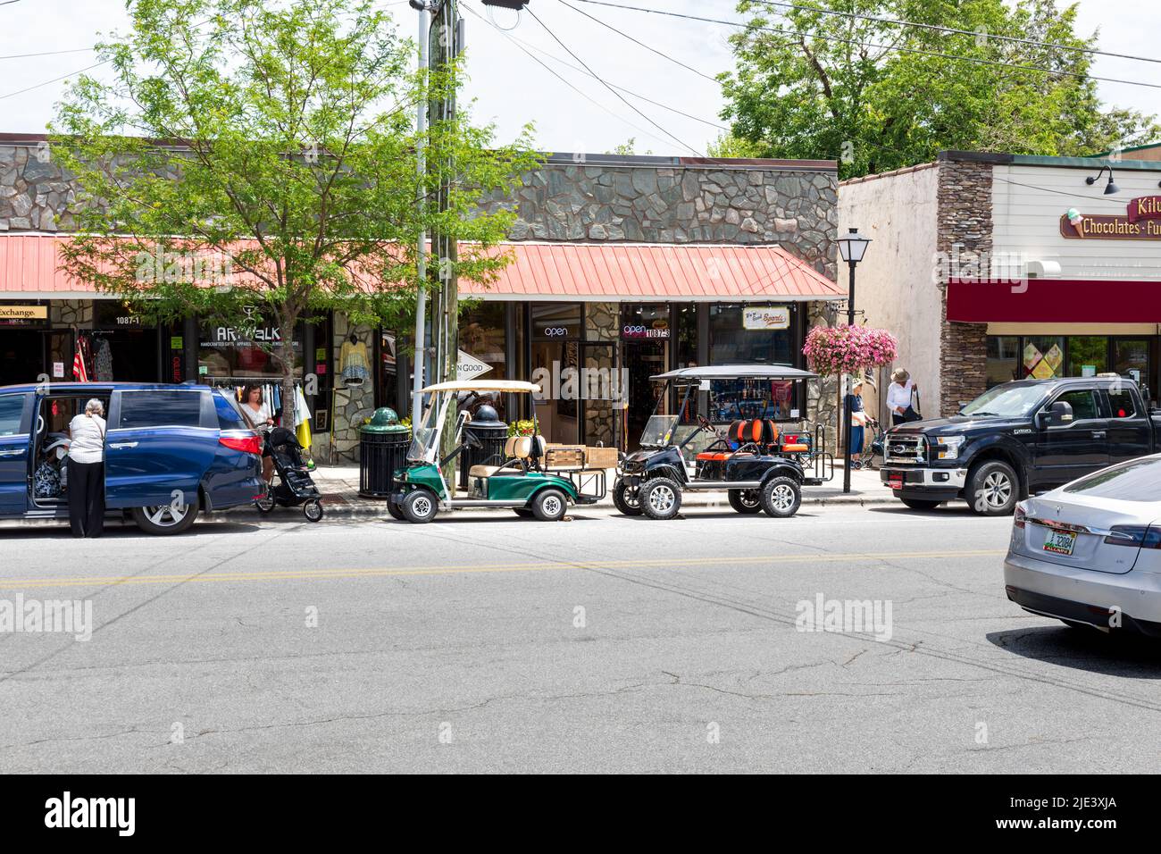 BLOWING ROCK, NC, USA-20 GIUGNO 2022: Main Street con due carrelli elettrici (stile golf) parcheggiati in parallelo. Molte persone. Foto Stock