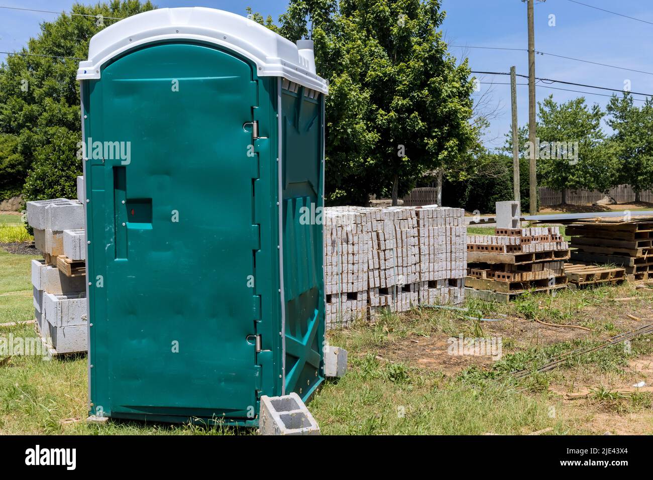 Un bagno portatile è disponibile per i lavoratori in un cantiere Foto Stock