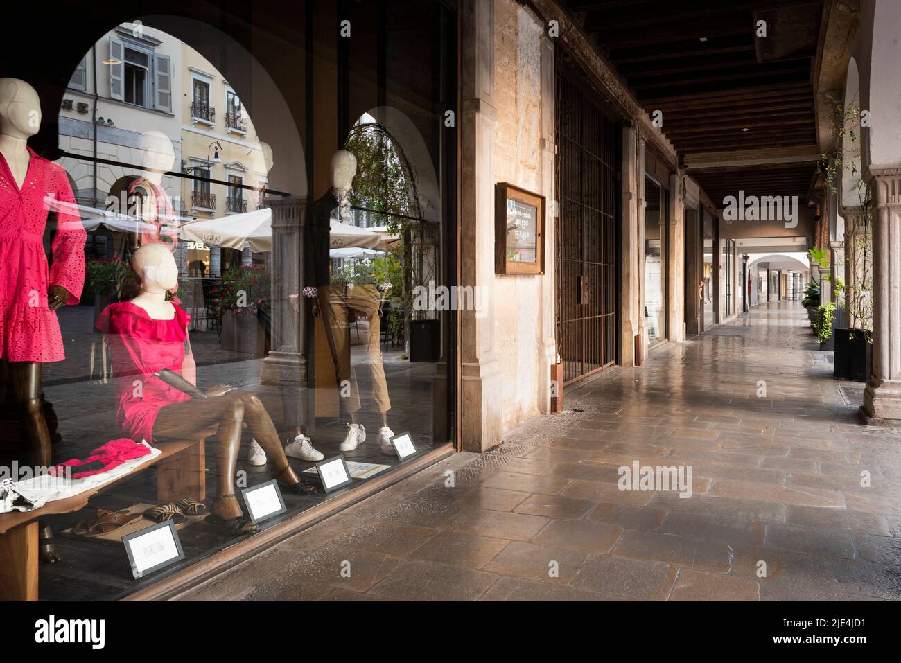 Vetrina di un negozio di moda sotto un portico. Tipica architettura e atmosfera classica italiana. Udine, Friuli Venezia Giulia, Italia. Foto Stock