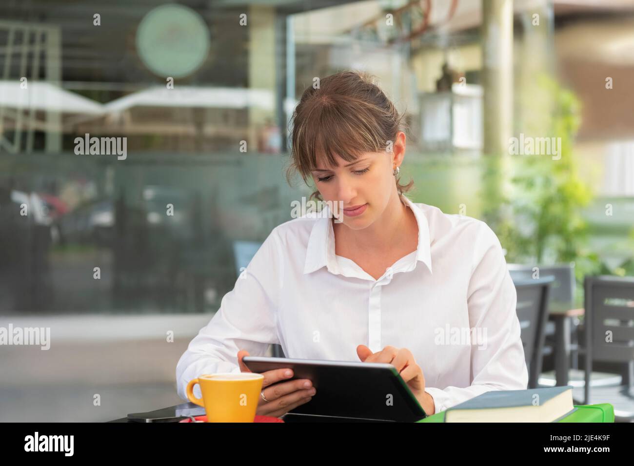 Giovane donna d'affari che ama il caffè e usa il tablet Foto Stock
