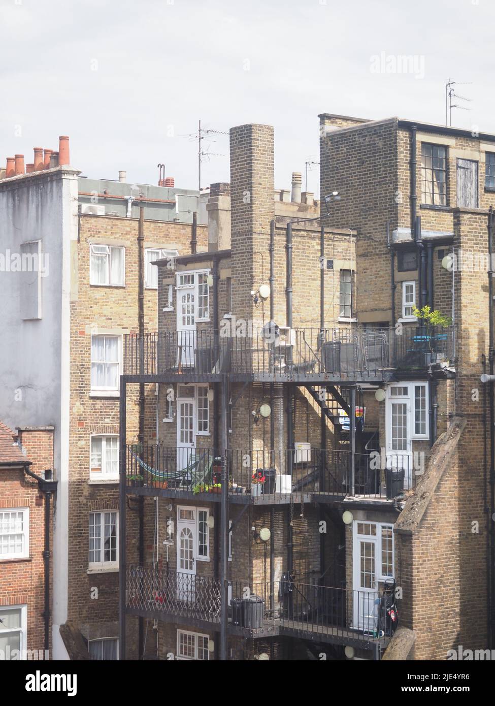 Dettagli interessanti sul retro di un edificio di Londra che mostra le fughe di fuoco in ferro e balconi Foto Stock