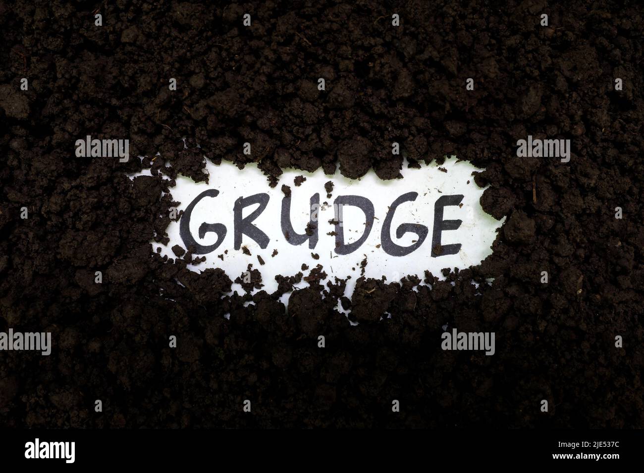 Seppellire il concetto di grudge e stop holding. Grudge parola di testo sullo sfondo del suolo. Foto Stock