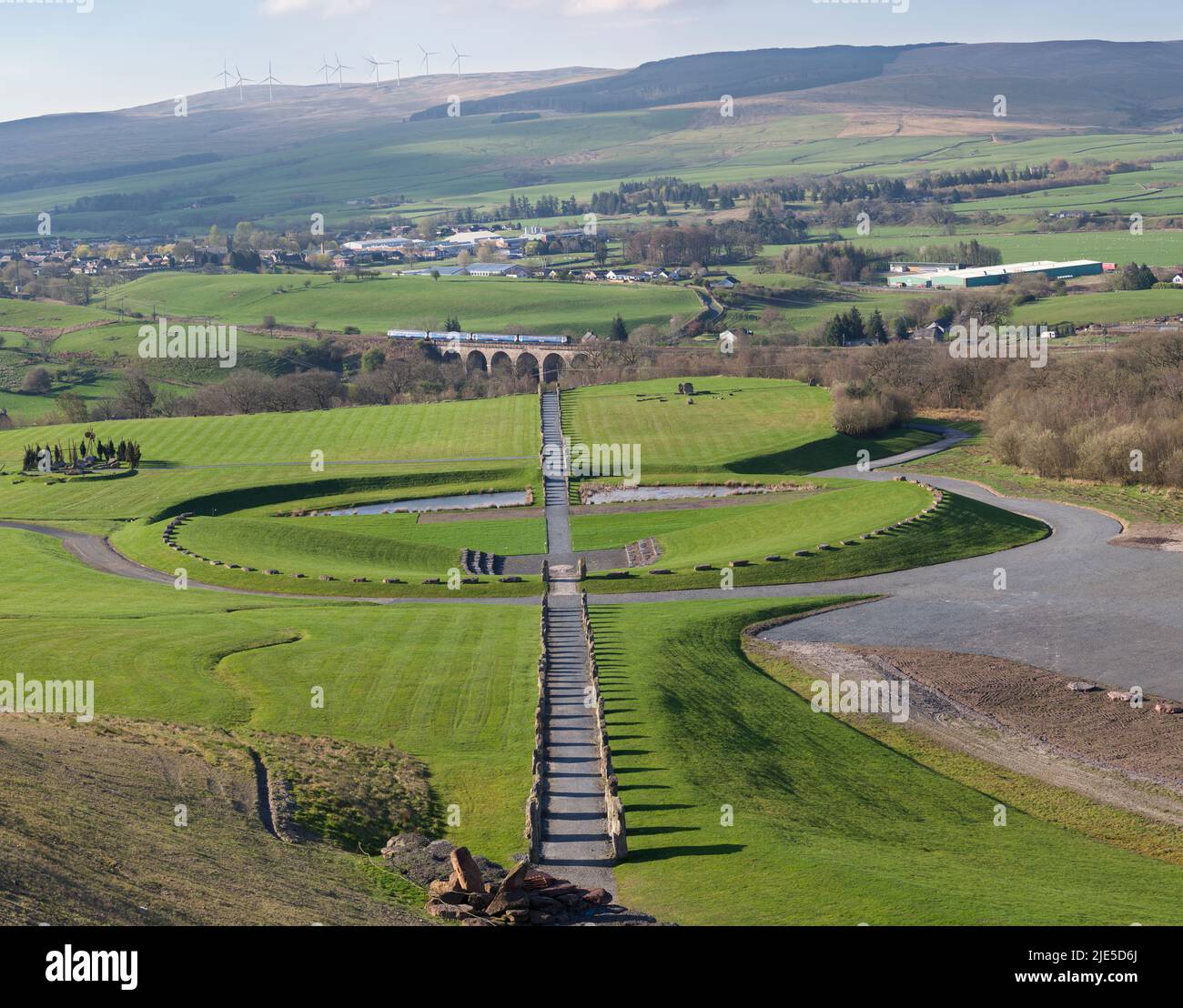 Crawick Multiverse scultura terra / arte terra e viadotto Crawick (Sanquhar, Dumfries e Galloway) con un treno locale Scotrail che passa Foto Stock