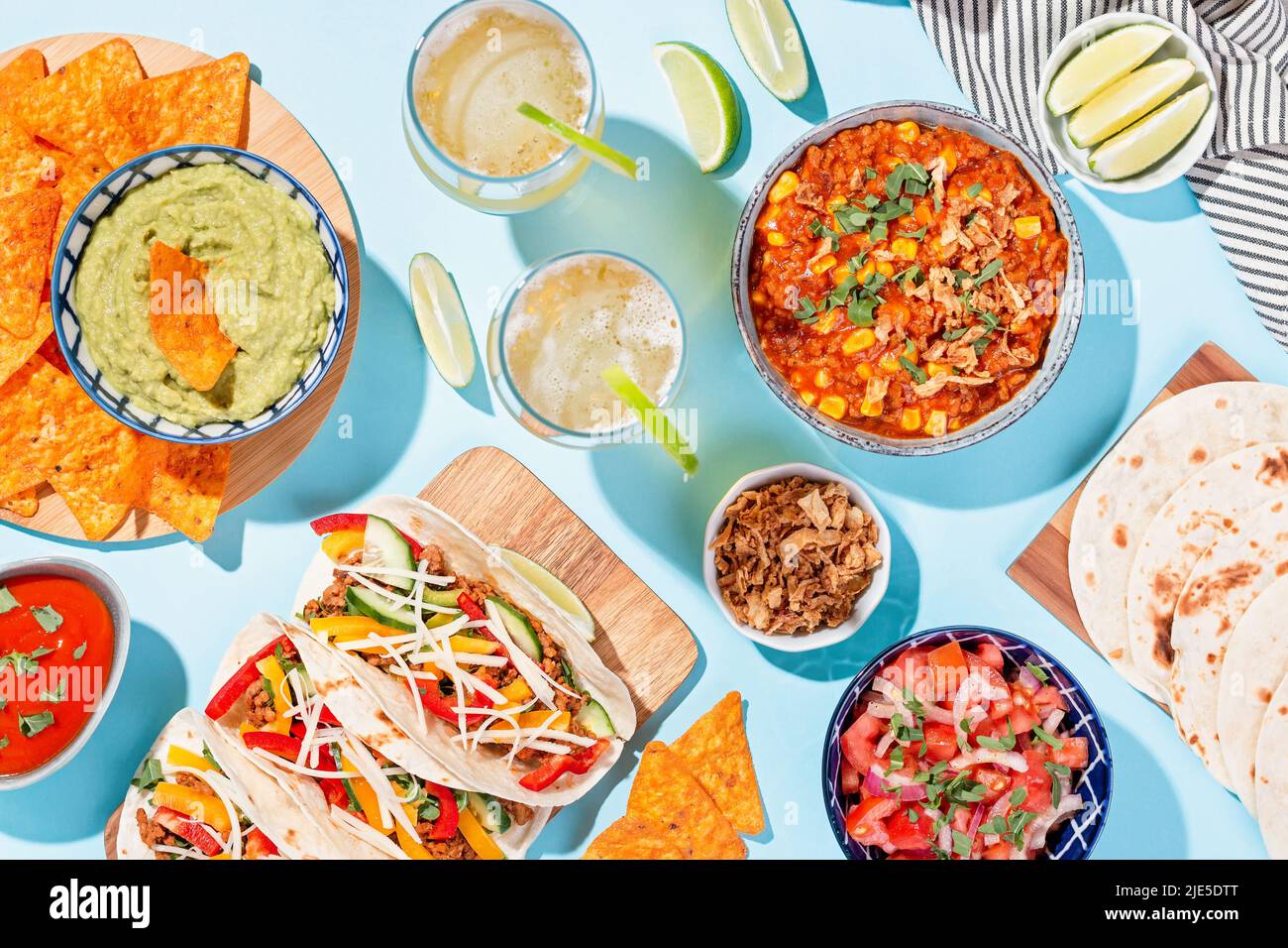Cucina messicana con piatti tradizionali. Chili con carne, tacos, salsa di pomodoro, patatine di mais con guacamole Foto Stock