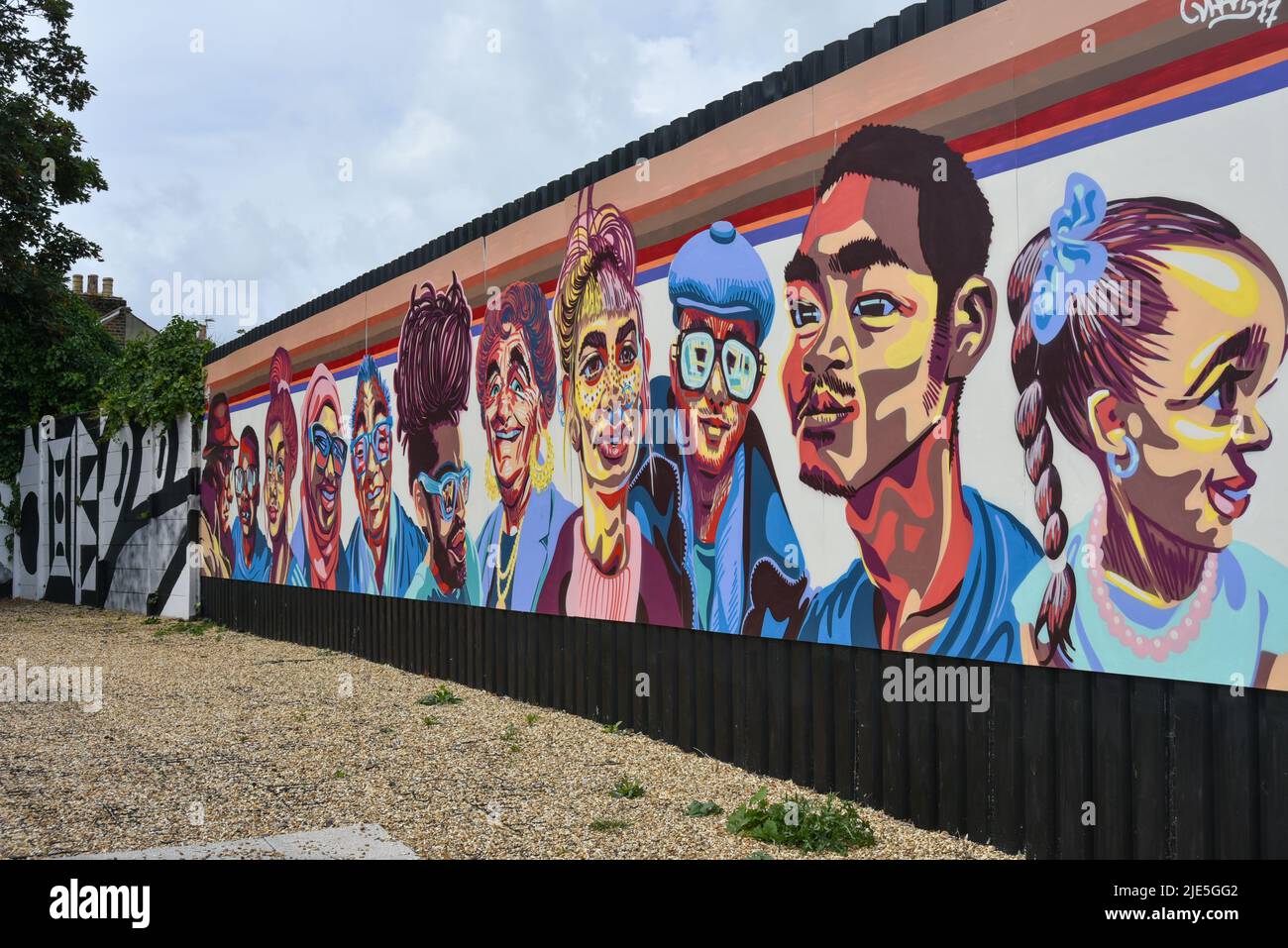 Bellissimo pezzo di Street art con facce multiculturali dipinte su un muro Foto Stock