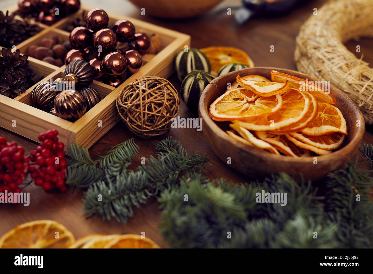 Primo piano di roba di Natale per decorare la corona su tavola di legno in studio di artigianato, spazio di copia Foto Stock