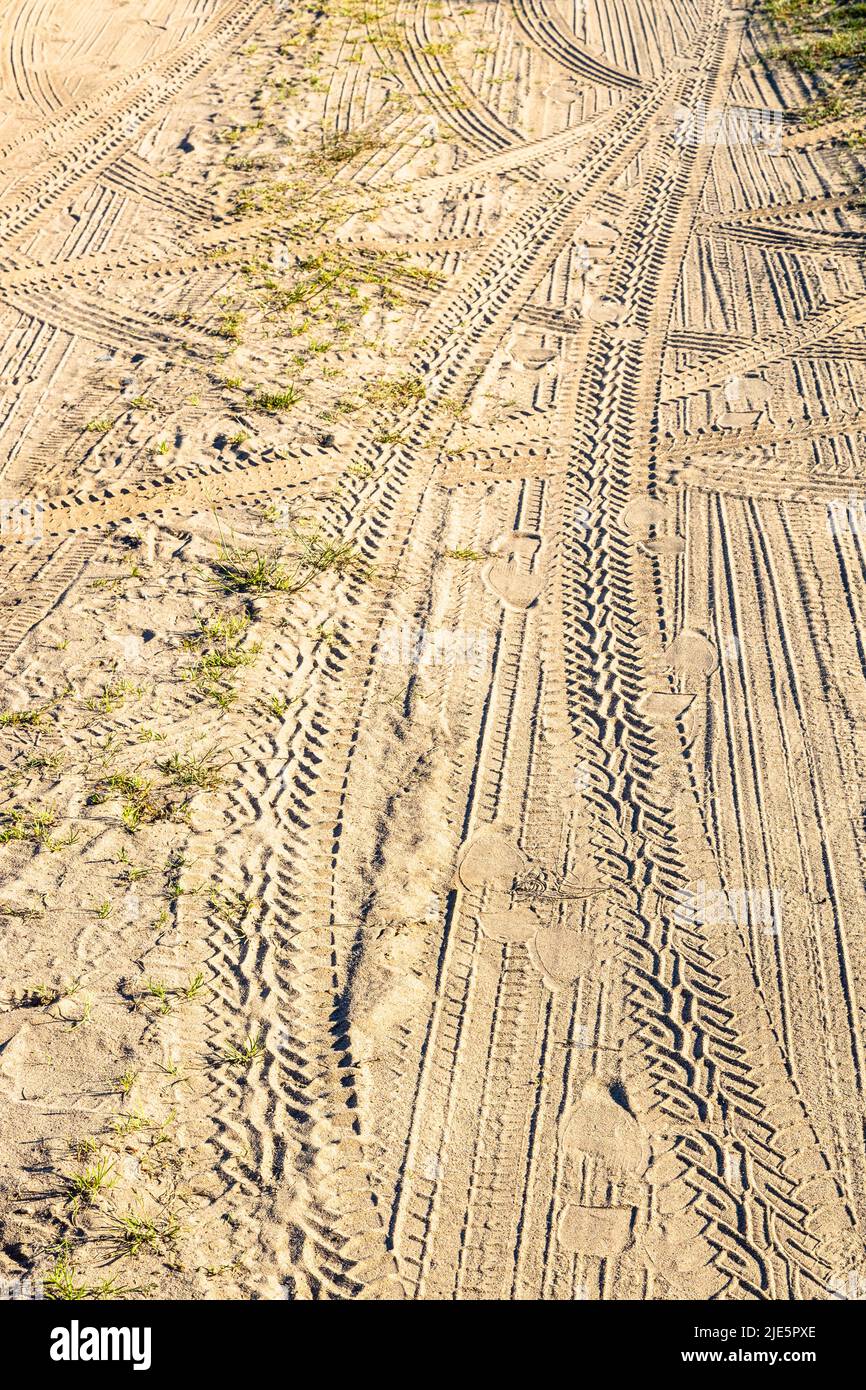 tracce di auto e impronte sulla superficie di sabbia strada sporca nel pomeriggio d'estate Foto Stock