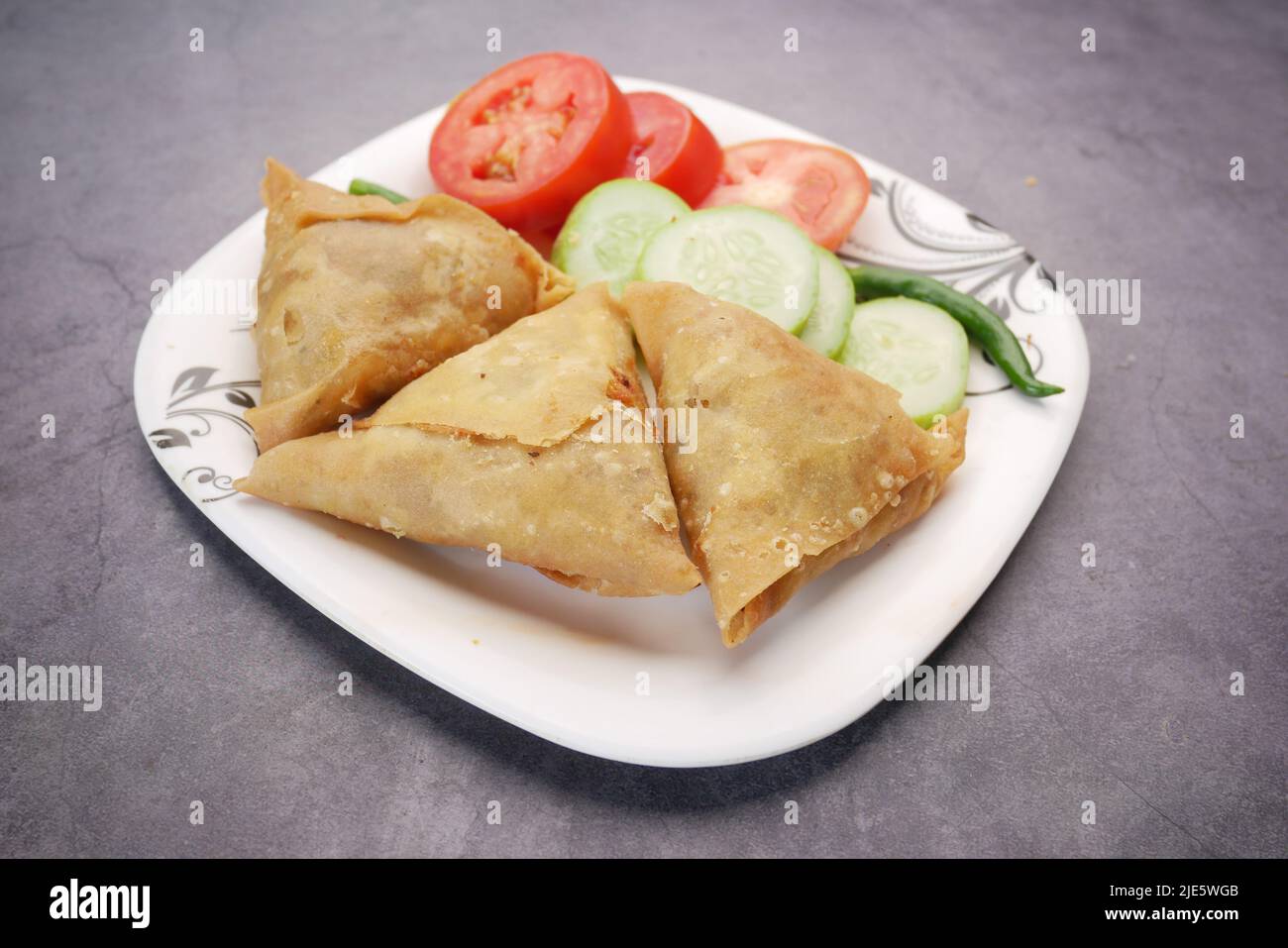 Vista dall'alto della samosa indiana e del pomodoro su un piatto Foto Stock