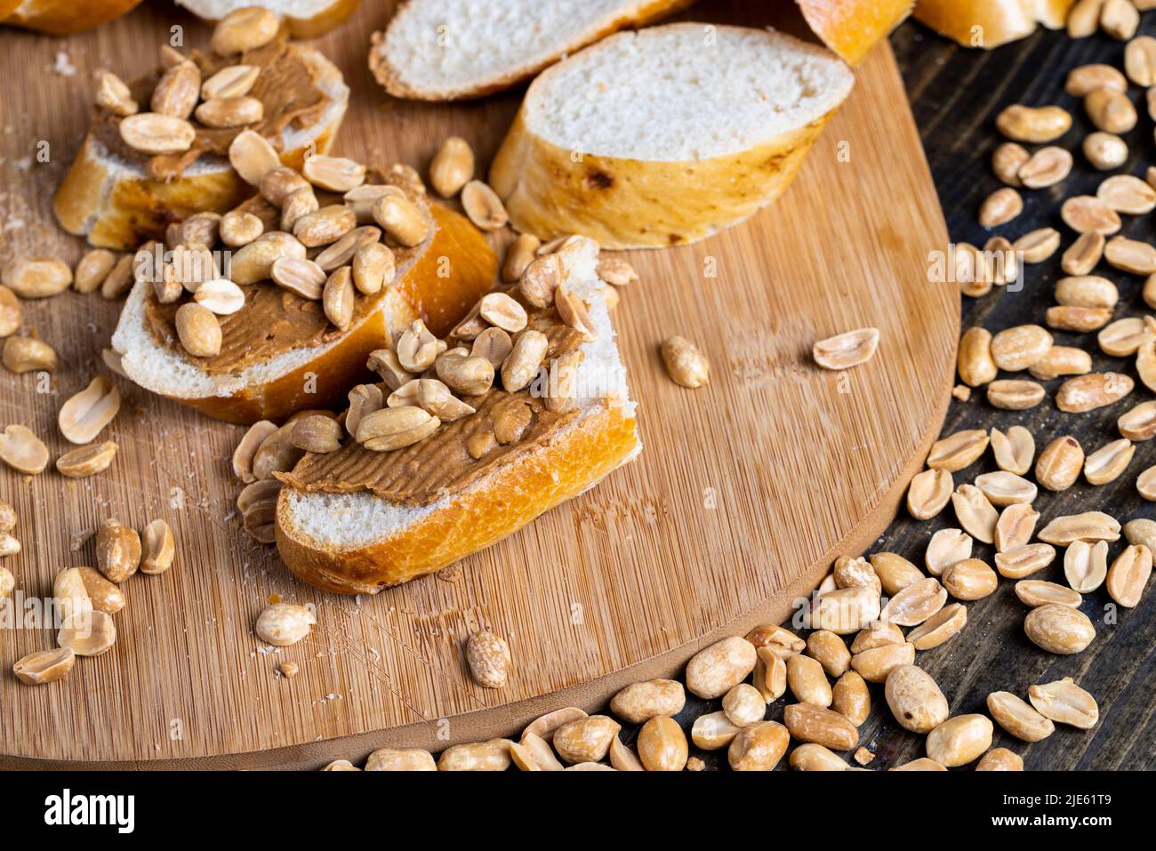 baguette di grano fresco e pasta di arachidi, facendo colazione di pane e burro di arachidi con pezzi di arachidi Foto Stock