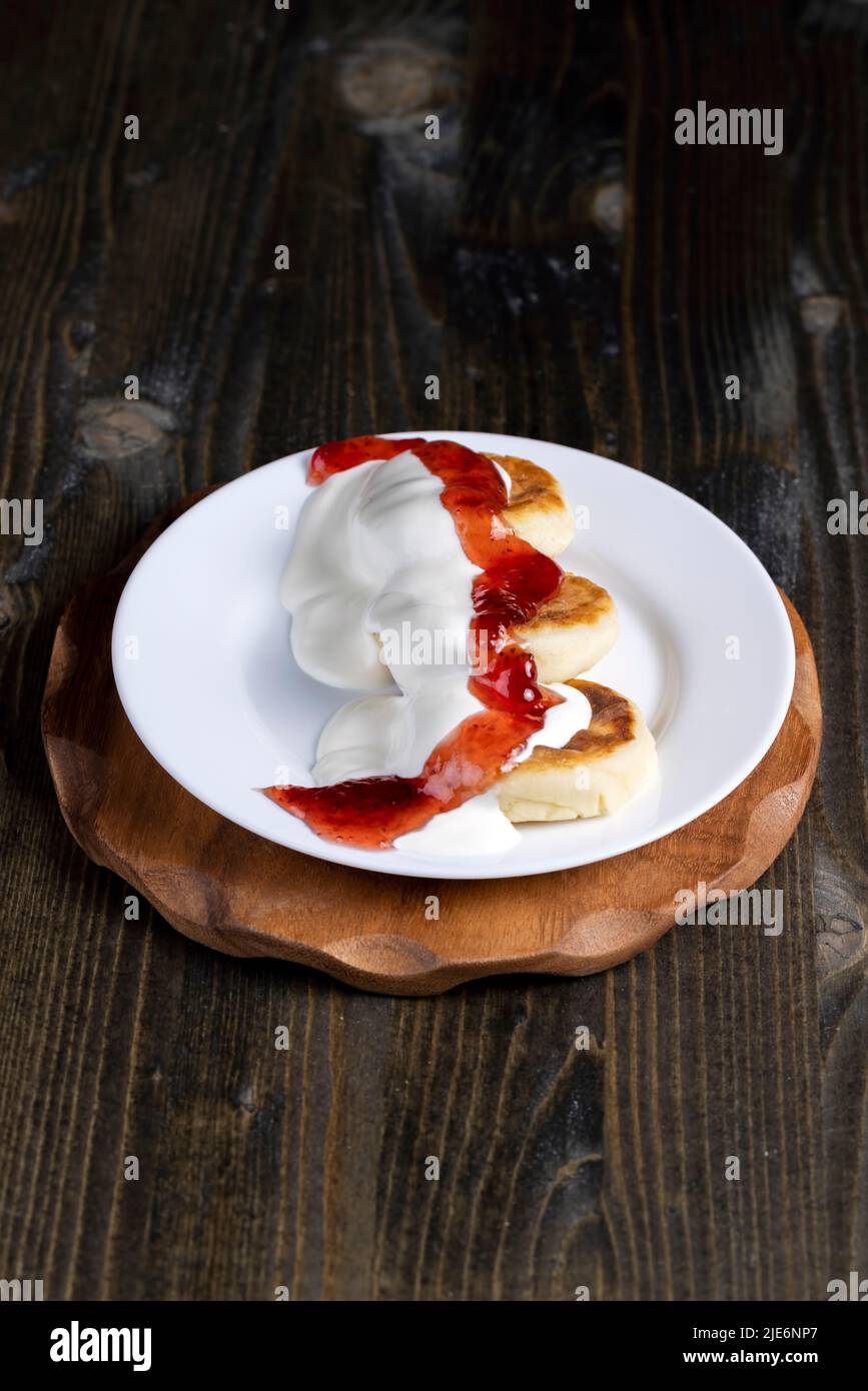 i dolci al formaggio casolare vengono consumati con panna acida o marmellata, deliziosa torta al formaggio cotta a casa Foto Stock