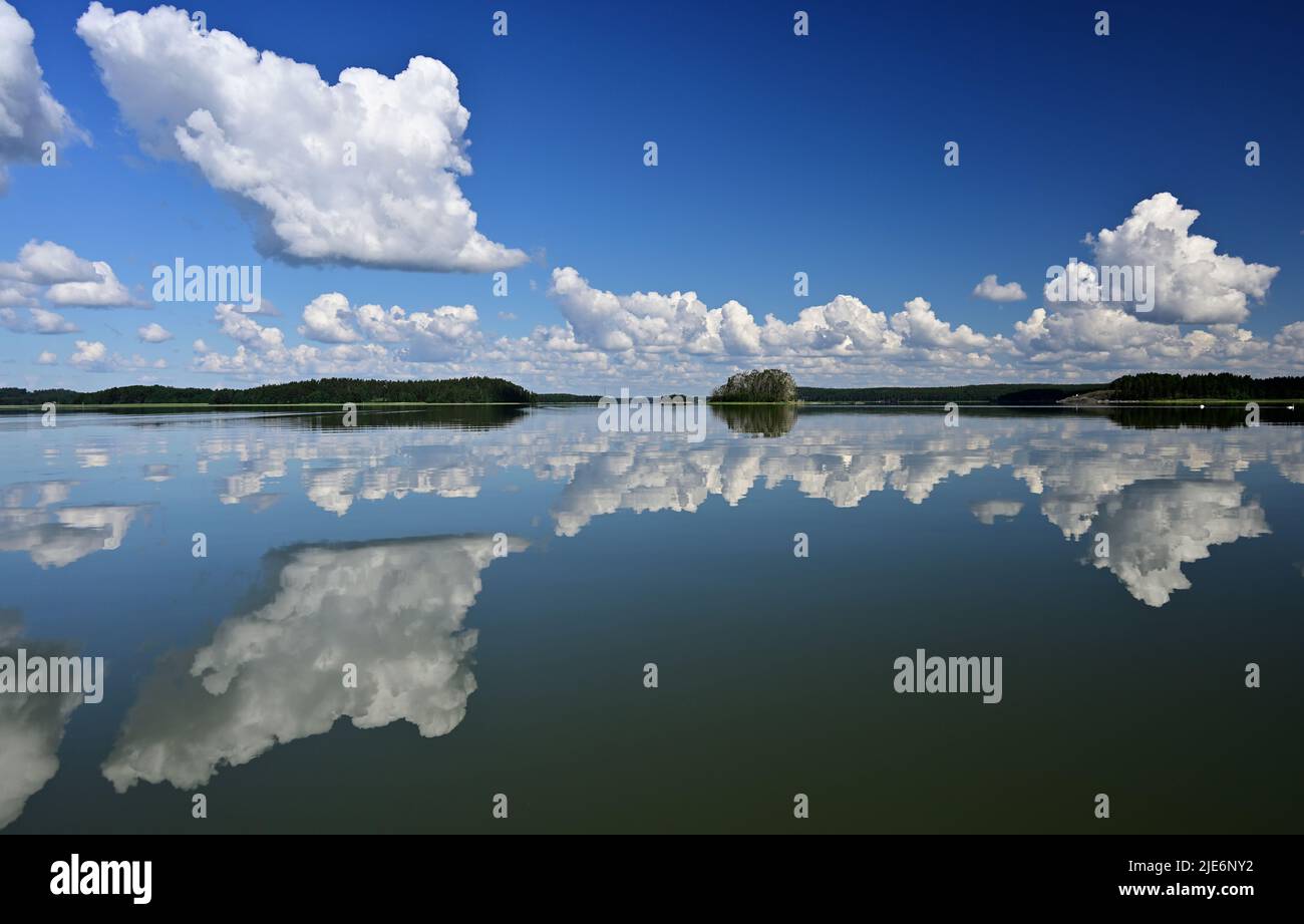 skerries del Mar Baltico in Finlandia in una giornata estiva di sole, le nuvole si riflettono nella superficie dell'acqua Foto Stock