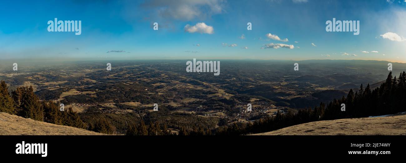 Vista panoramica aerea delle colline alpine a sud della Stiria dalla cima di Schöckl vicino a Graz con la nuvola di cielo blu nella soleggiata giornata invernale, Sankt Radegund, Au Foto Stock