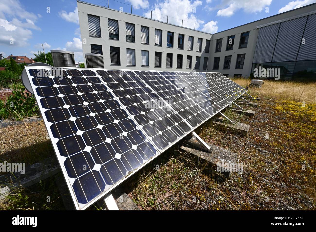 23 giugno 2022, Baden-Wuerttemberg, Öhringen: Un impianto fotovoltaico si trova sul tetto di un edificio Netze BW. L'operatore della rete di distribuzione Netze BW sta entrando in una fase decisiva con un progetto pilota per la fornitura di gas con quasi un terzo di idrogeno. Nel mese di luglio, parte della rete di gas naturale di Öhringen deve essere scollegata e fornita in modo indipendente. Foto: Bernd Weißbrod/dpa Foto Stock