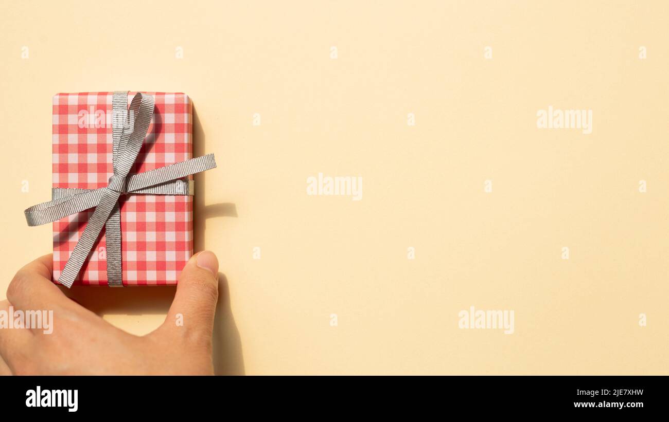 Scatola regalo a mano su sfondo beige. Vista dall'alto, spazio copia Foto Stock
