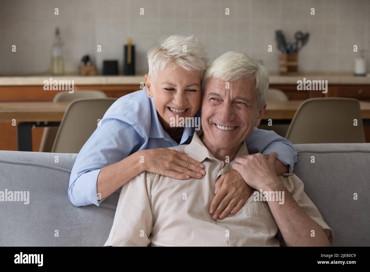 Ritratto moglie più anziana cudles marito ridendo passare il tempo a casa Foto Stock