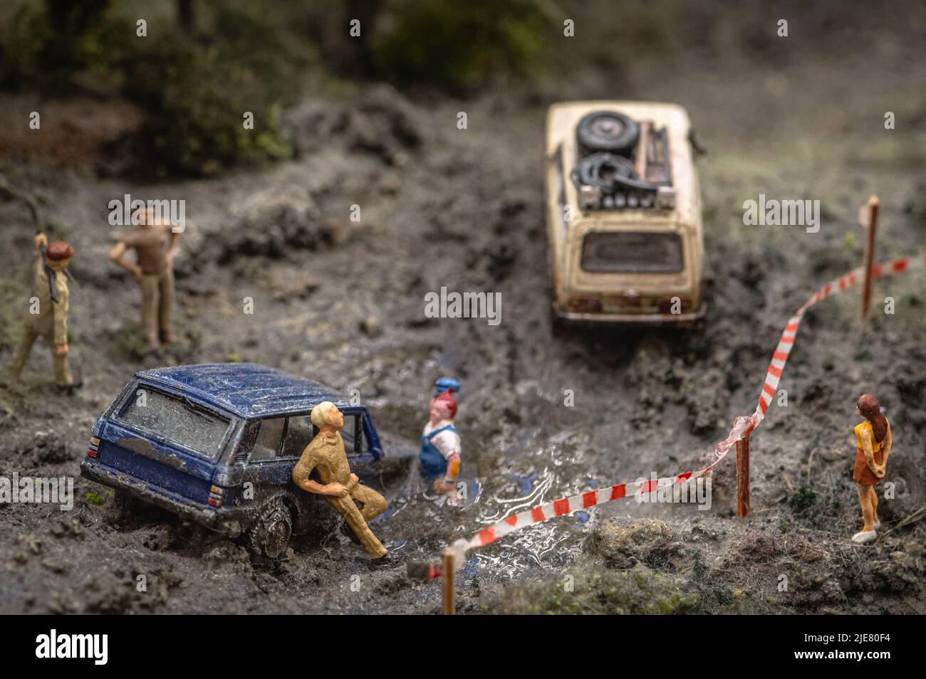 Rappresentazione giocattolo di automobili bloccate nel fango durante la corsa. Foto Stock