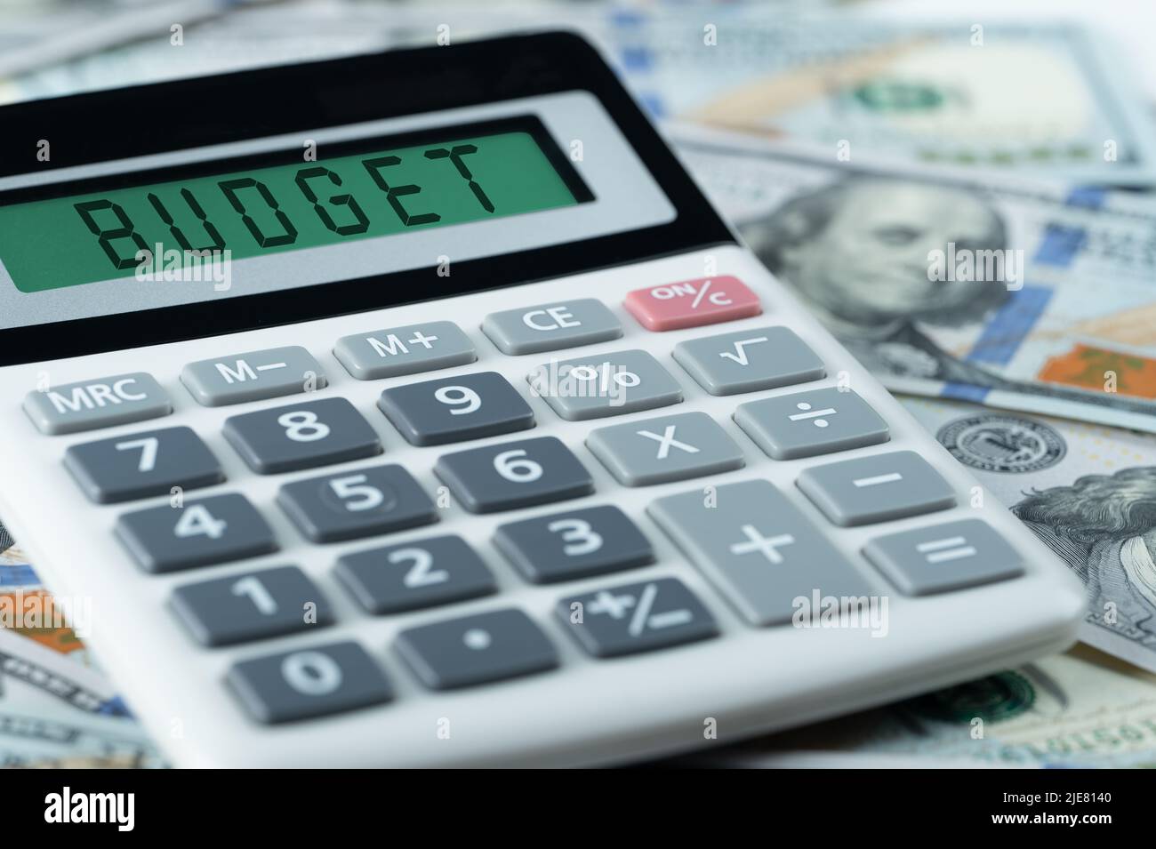 Concetto di budget testo di budget su calcolatrice. Testo di budget su calcolatrice su sfondo di dollari. Concetto di finanza e contabilità. Banconote e calcoli USA Foto Stock