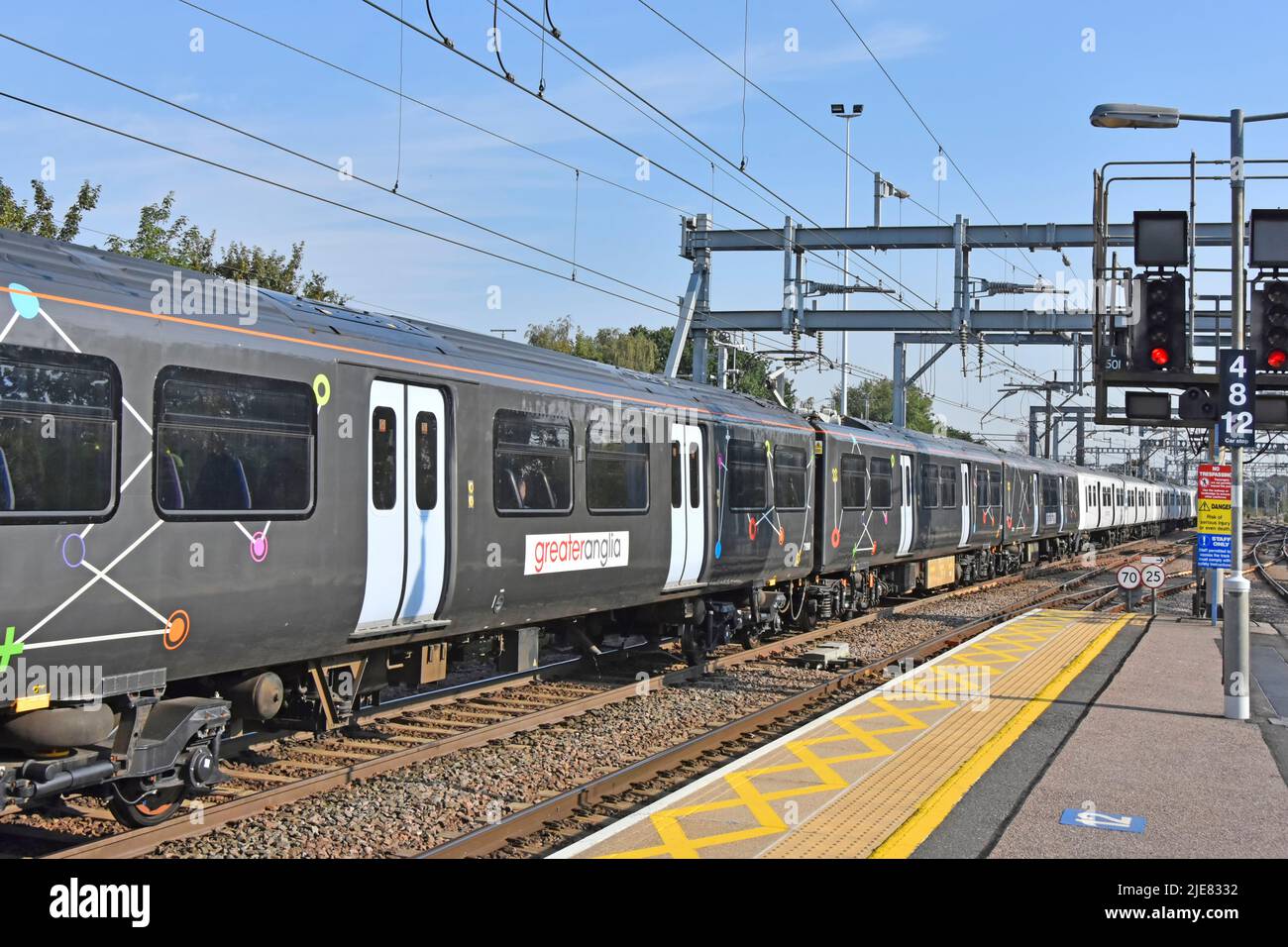 Carrozze elettriche Greater Anglia in inusuale colore grigio livrea con porte bianche e strana grafica lineare vista alla stazione ferroviaria di Shenfield nel Regno Unito Foto Stock
