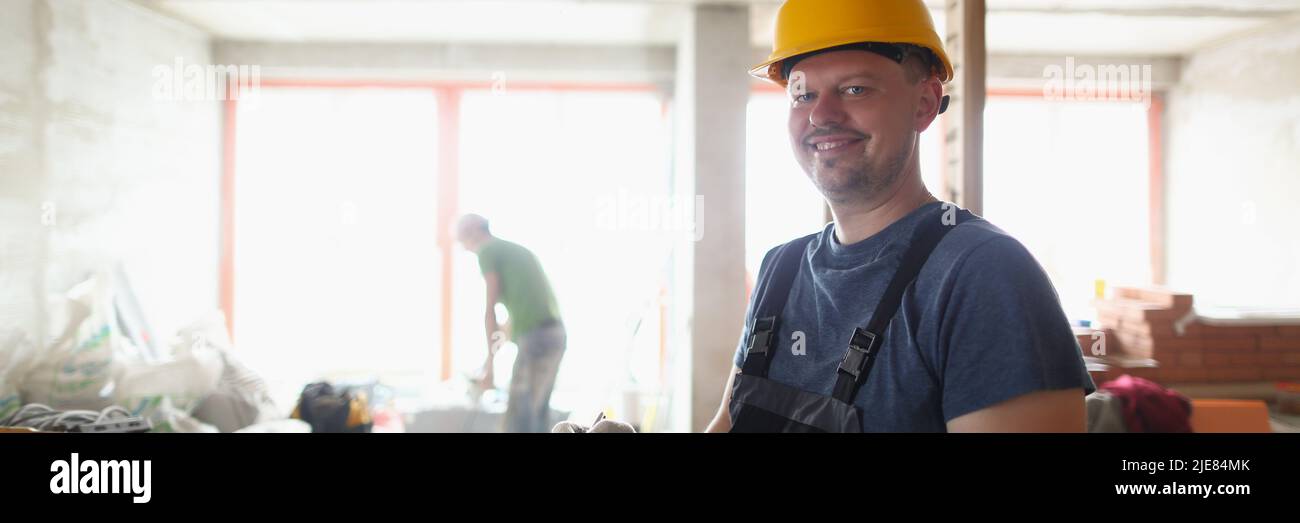 Un lavoratore professionale sorridente tiene appunti ed elenca i materiali di lavoro Foto Stock