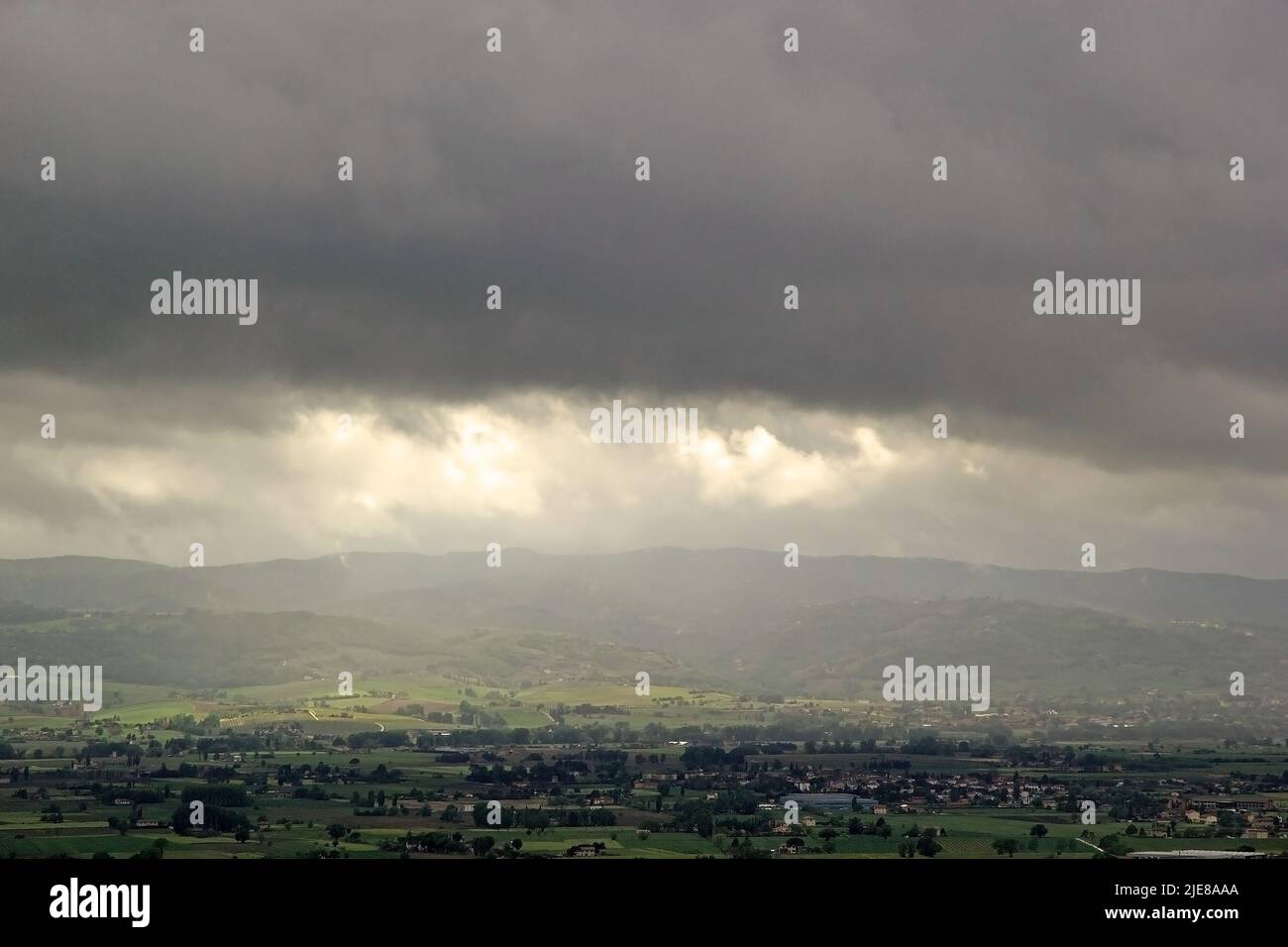 Temporale sulla pianura di Assisi, Italia, con Santa Maria degli Angeli sullo sfondo. Assisi è un comune della Regione Umbria, in provincia di Perugia Foto Stock