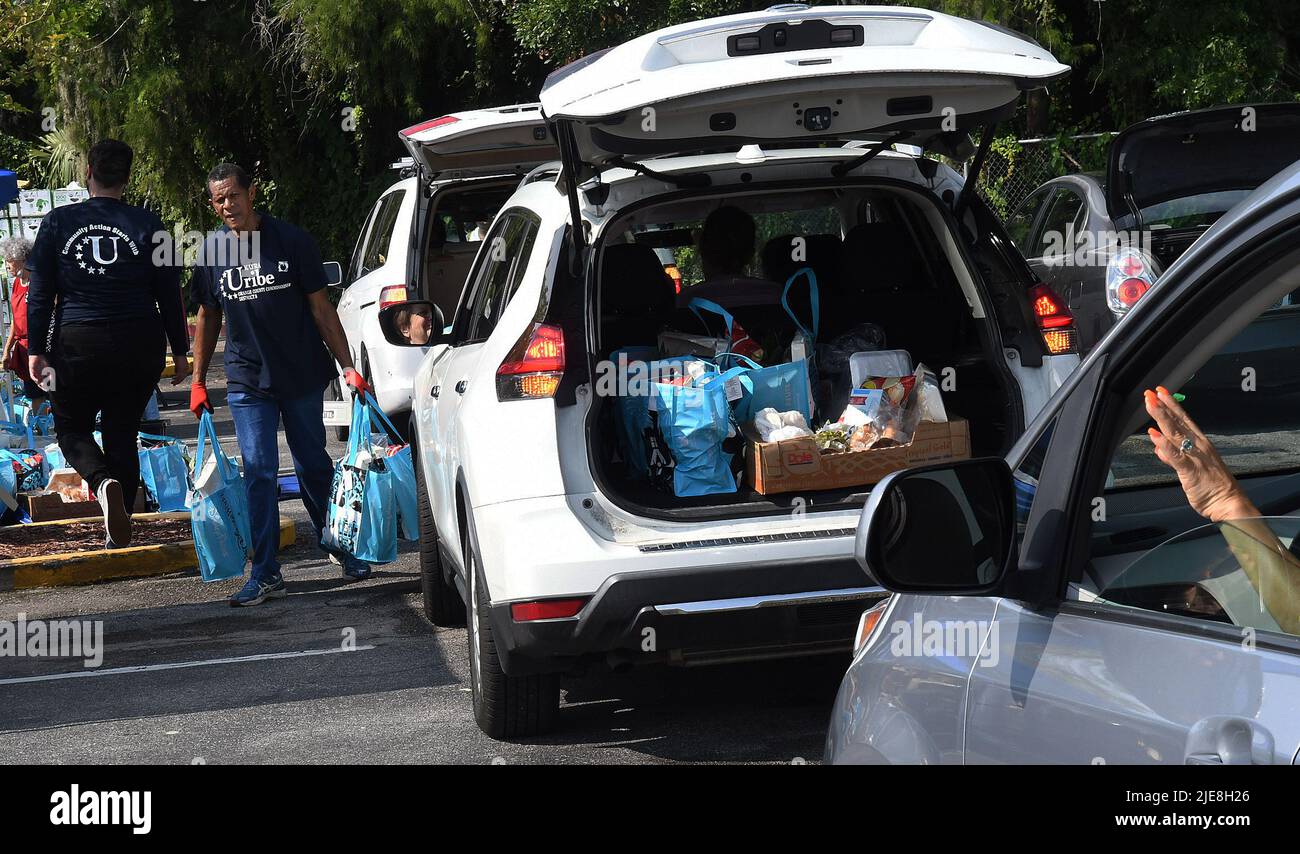 Orlando, Stati Uniti. 25th giugno 2022. I volontari caricano le borse di cibo nelle automobili ad un evento di distribuzione di cibo per i bisognosi sponsorizzato dalla seconda Harvest Food Bank della Florida Centrale e dalla contea di Orange alla chiesa di St. John Vianney ad Orlando, Florida. I prezzi elevati dei prodotti alimentari e del gas stanno schiacciando le famiglie lavoratrici, mandando alcune persone per la prima volta in panico per i prodotti alimentari, ma i fornitori stanno lottando con i costi dell’inflazione man mano che la domanda raggiunge i massimi livelli. Credit: SOPA Images Limited/Alamy Live News Foto Stock