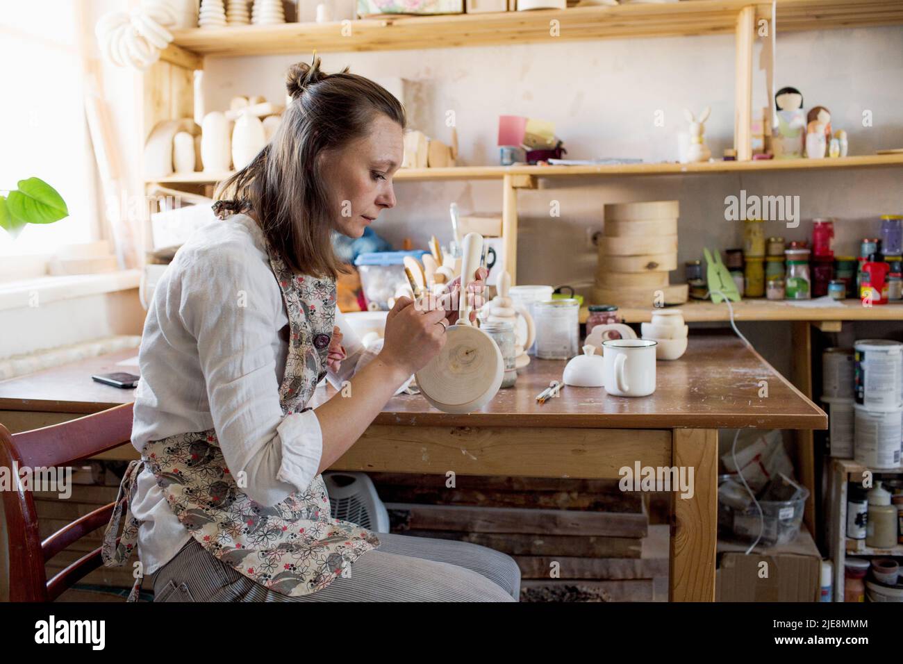 la ragazza della sua officina produce giocattoli in legno per bambini ecologici, di cui la propria produzione è una piccola impresa. Foto Stock