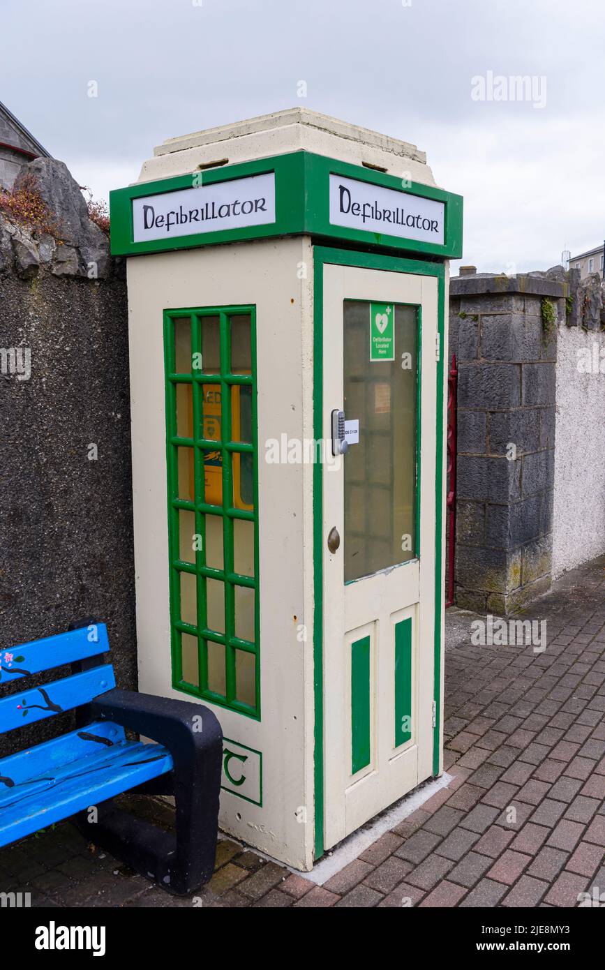Vecchia cassetta telefonica irlandese che è stata convertita in un luogo sicuro per la conservazione di un defibrillatore. Foto Stock