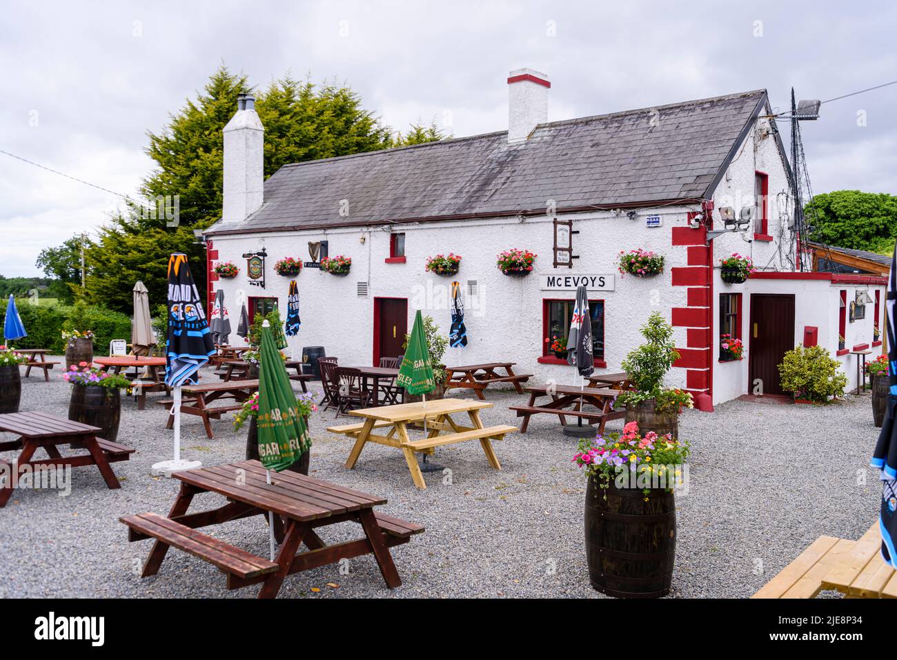 Grazioso e tradizionale pub rurale irlandese, con tavoli da picnic all'aperto. Foto Stock