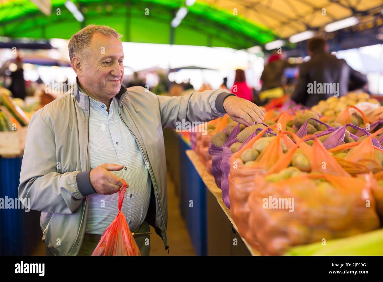 Uomo di mezza età che acquista patate Foto Stock