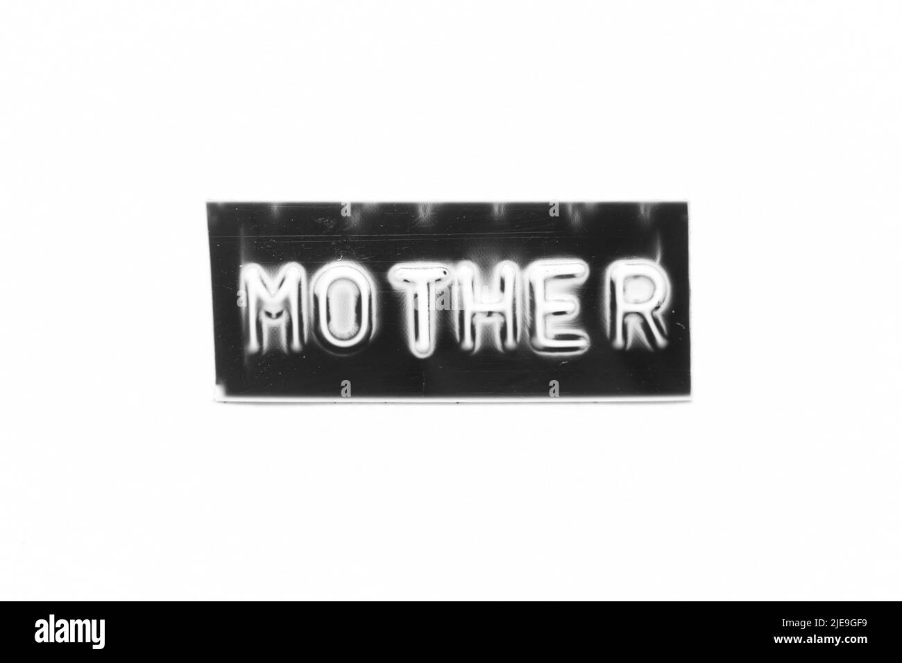 Banner di colore nero con lettera in rilievo con parola madre su sfondo di carta bianca Foto Stock