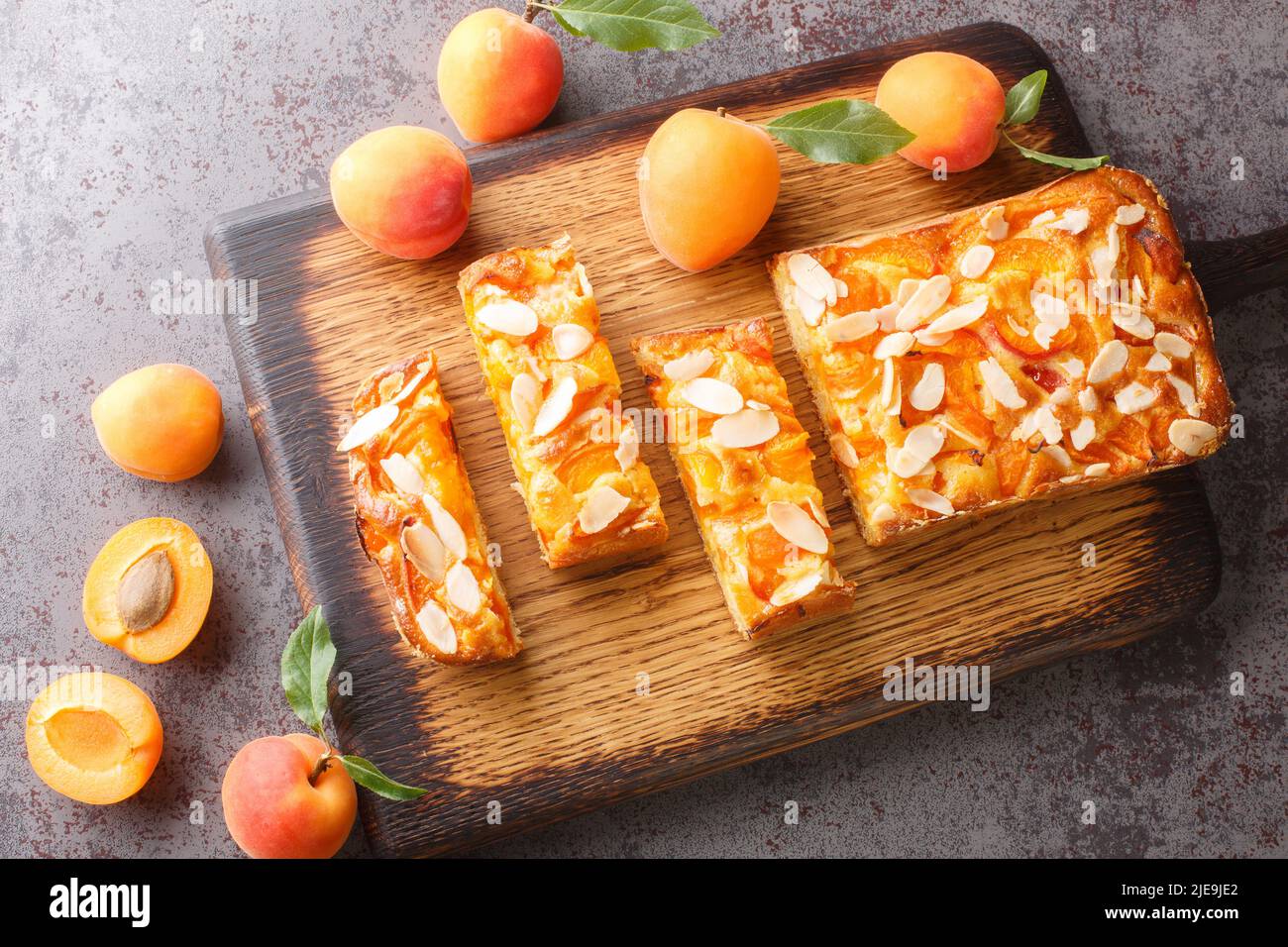 Estate torta di albicocche fresche con mandorle da vicino su un asse di legno sul tavolo. Vista orizzontale dall'alto Foto Stock