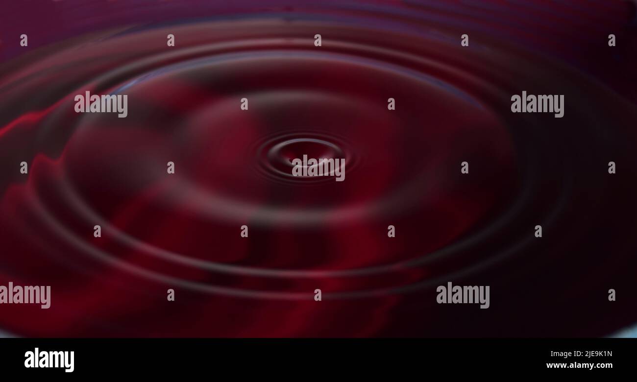 Water drop Fotografia: Acqua rossa con increspature da gocce d'acqua. Foto Stock