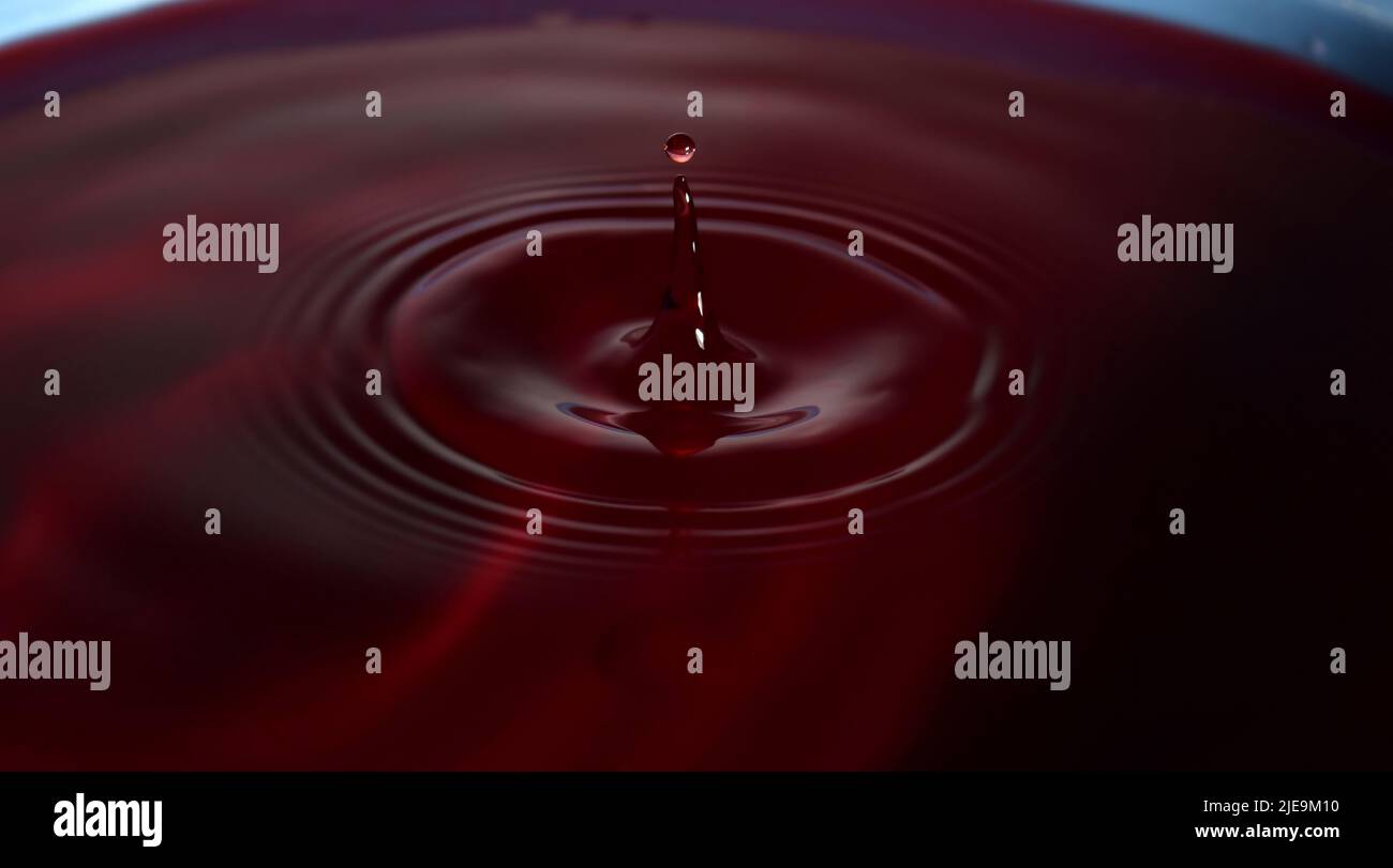 Foto gocce d'acqua: Gocce d'acqua rossa con guglia. Foto Stock