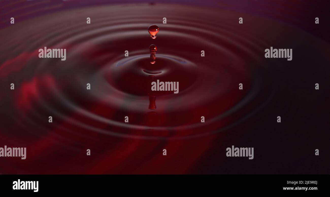 Foto gocce d'acqua: Gocce d'acqua rossa con guglia. Foto Stock