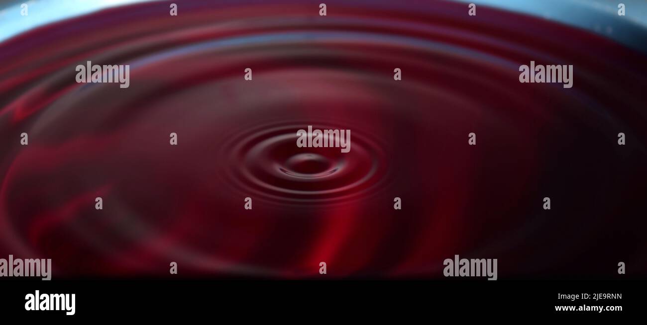 Water drop Fotografia: Acqua rossa con increspature da gocce d'acqua. Foto Stock