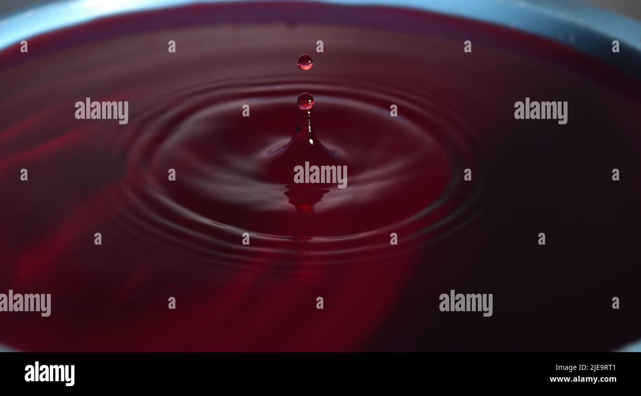 Foto gocce d'acqua: Gocce d'acqua rossa con guglia. Foto Stock