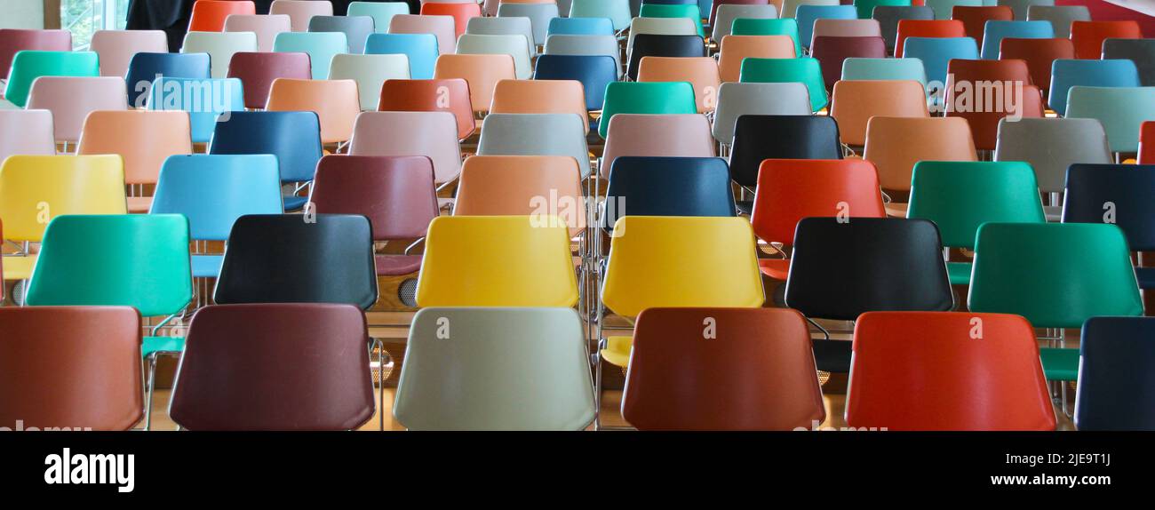 Vista frontale ravvicinata di un auditorium vuoto con posti colorati. Foto Stock