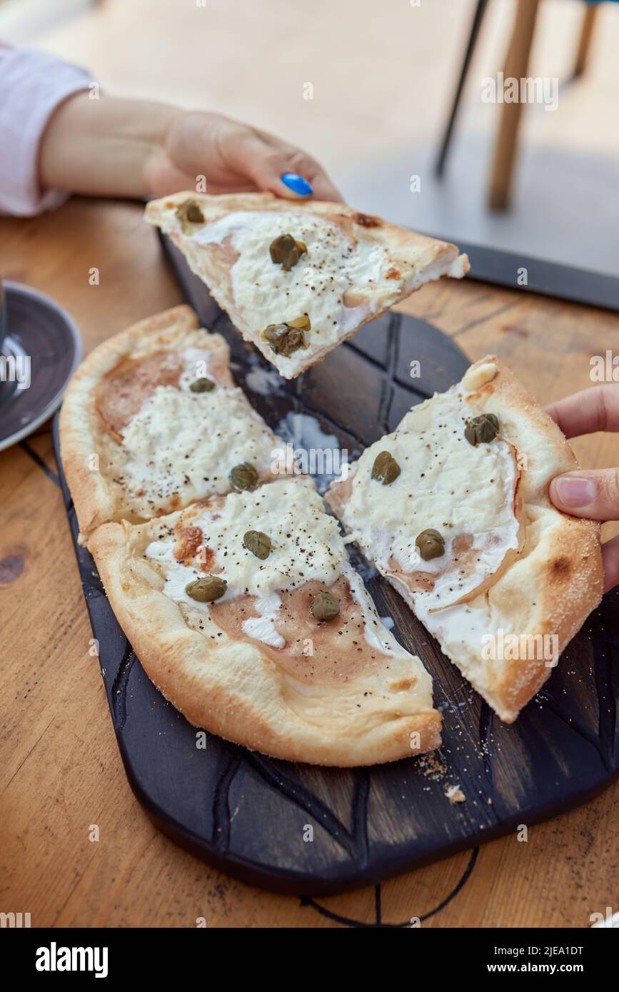 Pizza molto cheesy di sei tipi di formaggio e pistacchi. Cucina italiana. Vista dall'alto Foto Stock