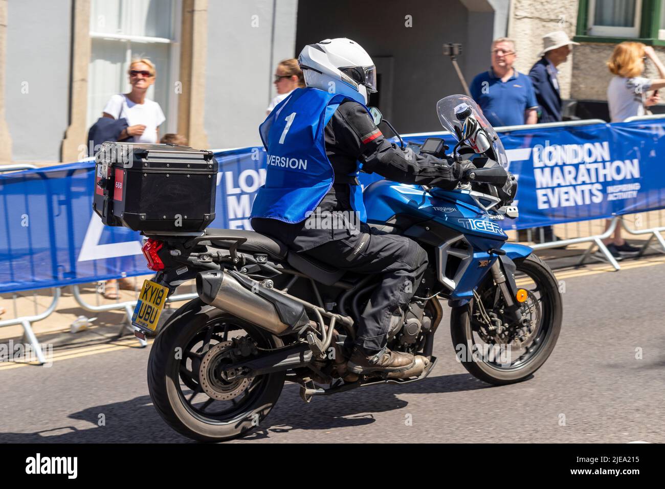 Rolling Road Block motociclista che guida il corso di gara stradale attraverso la città di Maldon durante la UCI RideLondon Classique femminile corsa ciclistica Foto Stock