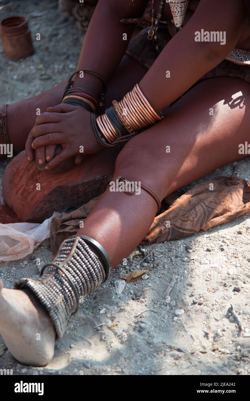 Donna irriconoscibile della tribù himba che lavora con argilla nelle sue mani. L'argilla è usata per proteggere i capelli e la pelle. Regione di Epupa, Namibia. Africa Foto Stock