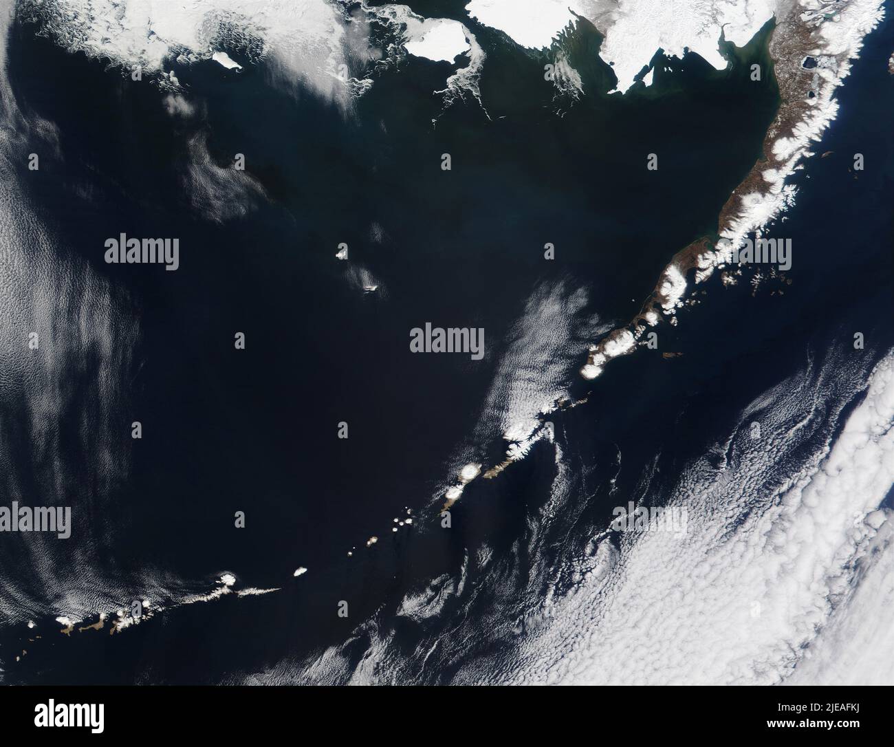 Alaska's Aleutian Islands, bordo settentrionale del Pacifico Ring of Fire. Le zone bianche circolari di alcuni dei crateri innevati dei vulcani possono essere s Foto Stock