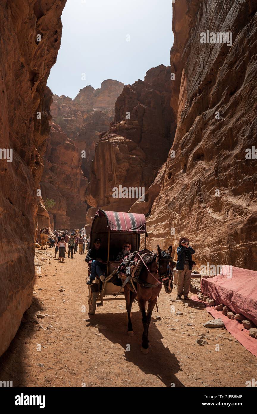 Petra, Giordania - 4 maggio 2022: Carrozza che passa attraverso il canyon Siq in Petra Ancient Rock Cut City in Giordania. Famoso sito archeologico nel sout della Giordania Foto Stock
